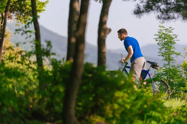 冒险的山地自行车手骑着自行车在树林中疾驰而过 — 图库照片