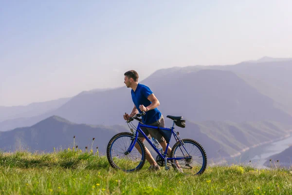 Müder, fitter Mountainbiker schiebt sein Rad bergauf — Stockfoto