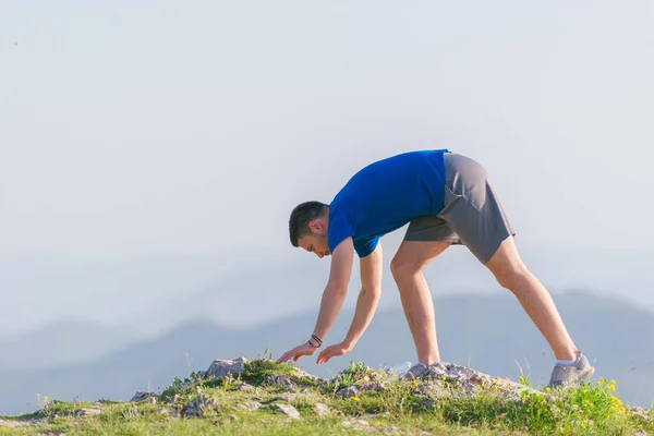 Un giovane atleta maschio in forma sta facendo flessioni all'aperto su una scogliera w — Foto Stock