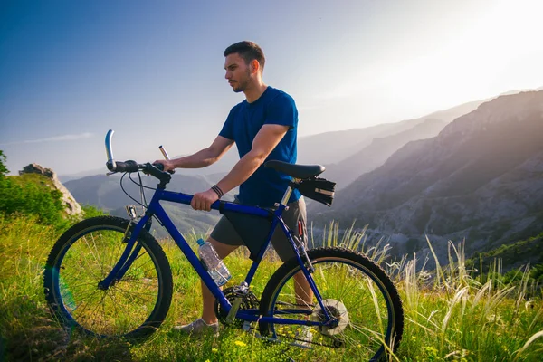 一个健康的山地自行车手驾驶着他的自行车爬山的视角 — 图库照片