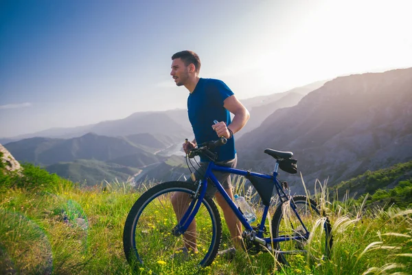 Perspectief van een fitte mountainbiker duwen zijn fiets bergop met — Stockfoto