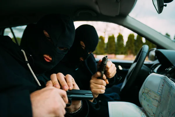 Bank robbers with their masks on pointing at the map prepared fo — Stock Photo, Image