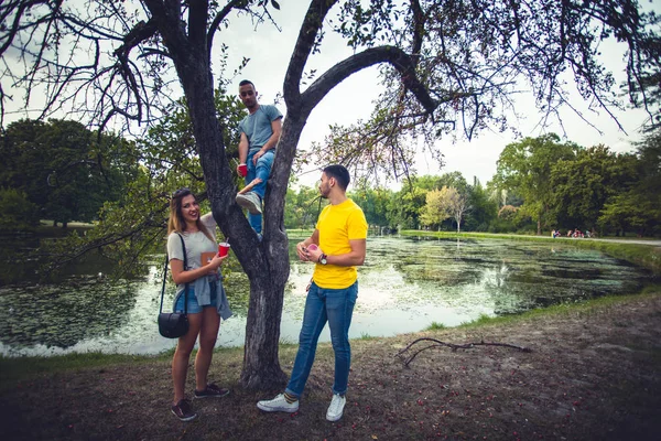 Νέοι Άνθρωποι Χαζολογούν Τον Φίλο Του Που Στέκεται Στο Δέντρο — Φωτογραφία Αρχείου