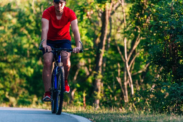 健康的骑自行车者骑自行车在空旷的路上 — 图库照片