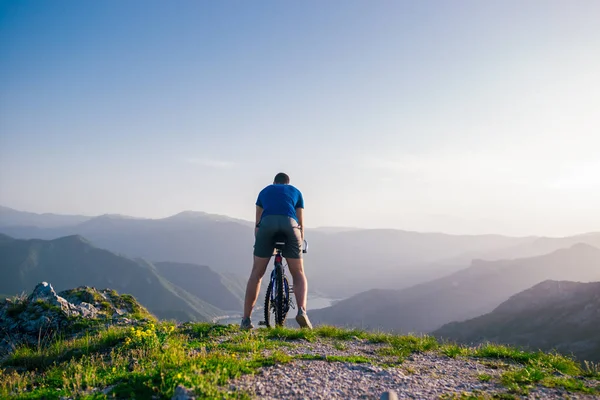 Kalandvágyó kerékpáros lovaglás a mountain bike szélén egy cl — Stock Fotó