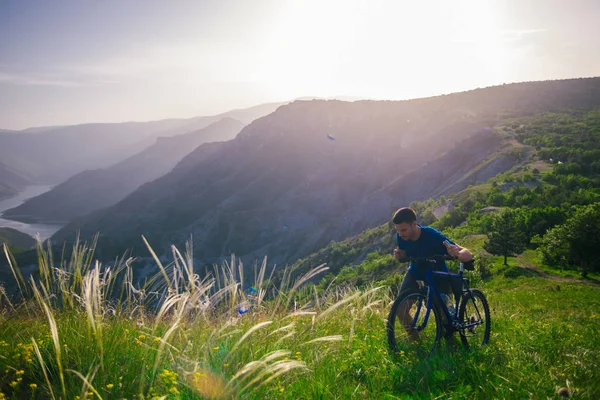 Perspectief van een fitte mountainbiker duwen zijn fiets bergop met — Stockfoto