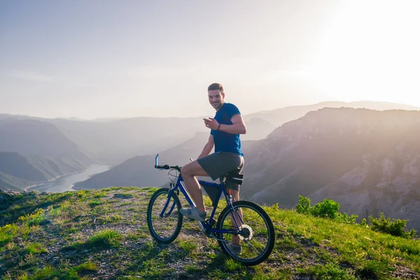 Aventuroso ciclista montando sua bicicleta de montanha na borda de um cl — Fotografia de Stock