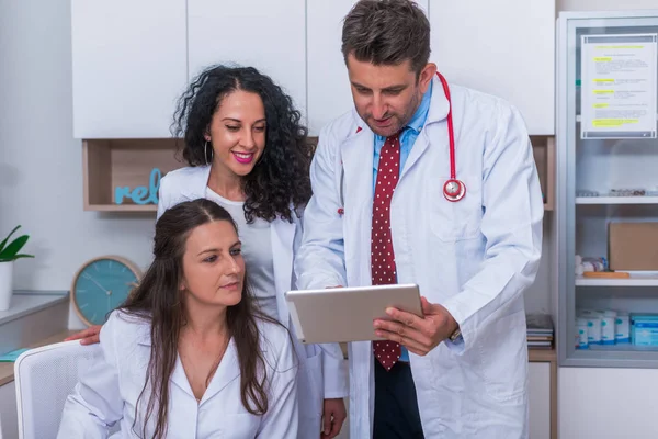 Zwei Krankenschwestern (Ärztinnen) und ein Arzt, der in einem — Stockfoto