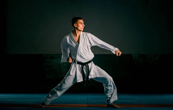 Un kata de karate entrenando al hombre aislado sobre fondo oscuro — Foto de Stock