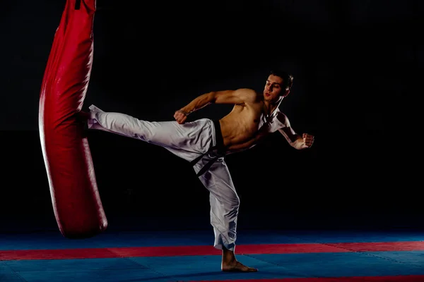拳击手训练在健身房的踢袋隔离在黑色沃尔 — 图库照片