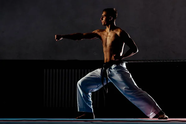 Hombre joven está practicando artes marciales en el gimnasio deportivo — Foto de Stock