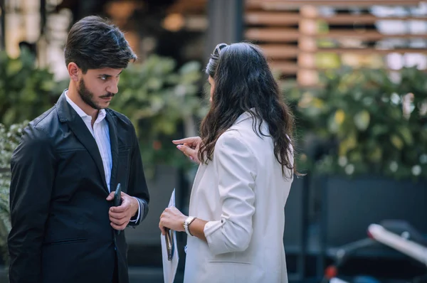 Senhora de negócios positiva falando com colega de trabalho quando eles estão de pé — Fotografia de Stock