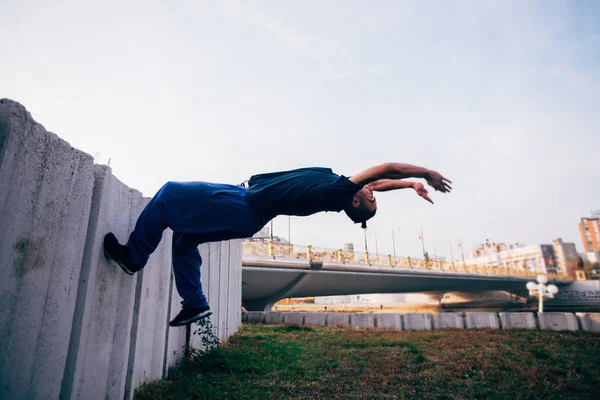 Молодий чоловік у 20-х робить паркур трюк в громадському місці в — стокове фото