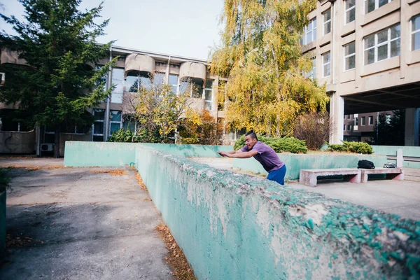 Athletic Parkour guy doing backflip and tricks while jumping off — Stock Photo, Image