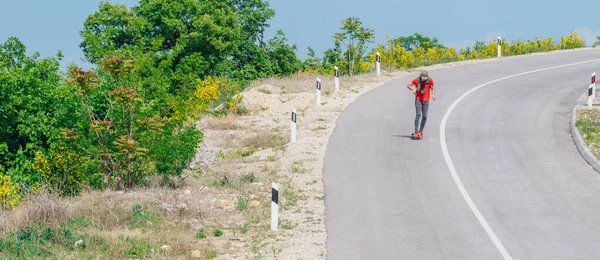 Männliche kaukasische Longboarder fahren bergab auf einer leeren Straße, pre — Stockfoto