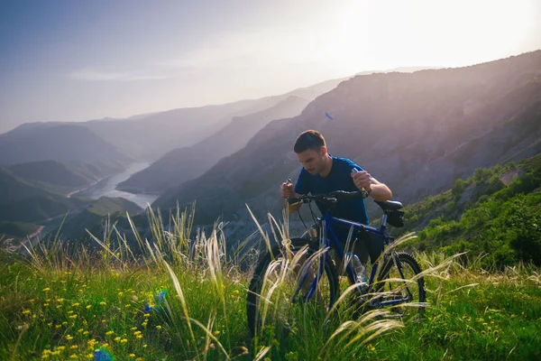 Perspectief van een fitte mountainbiker duwen zijn fiets bergop met — Stockfoto