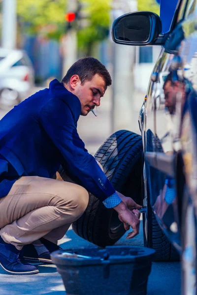 Formelt Kledd Gentleman Med Blå Blazer Skifter Dekk Bilen Sin – stockfoto