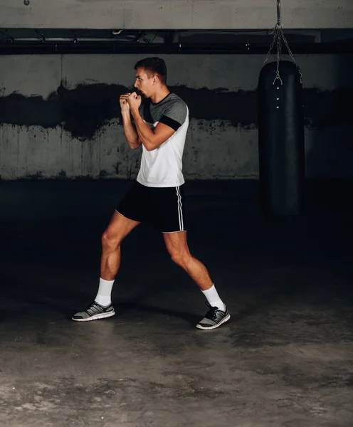 Man throwing a fierce and powerful punch. Photo of muscular man. Strength and motivation