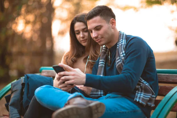 Junges Paar Hört Musik Lächelt Schaut Auf Das Telefon Und — Stockfoto