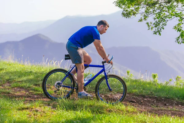 Fit mountain bike kerékpáros kerékpáros keresztül zöld fű tetején — Stock Fotó