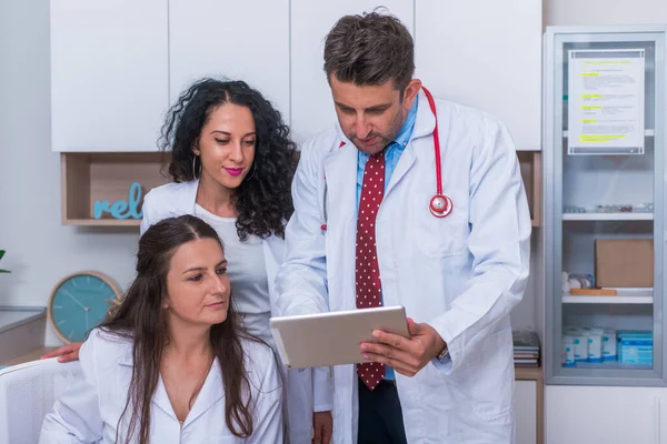 Zwei Krankenschwestern (Ärztinnen) und ein Arzt, der in einem — Stockfoto