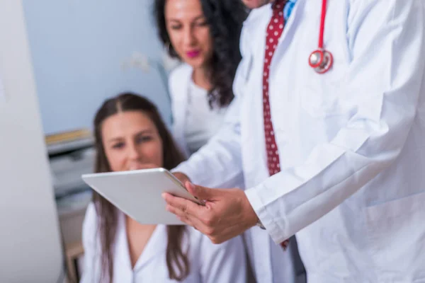 Dos enfermeras (mujeres médicos) y un médico varón que estudian en un hospital — Foto de Stock