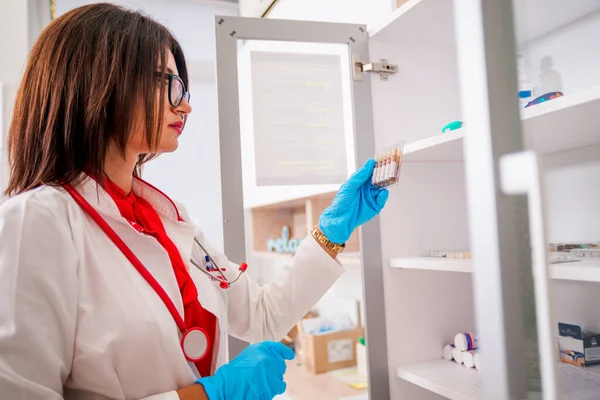 Mujer (mujer) Médico (enfermera) sosteniendo una jeringa mientras está de pie —  Fotos de Stock