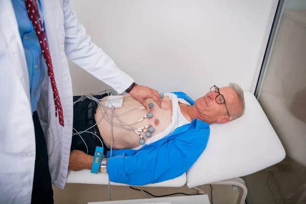 Γιατρός (καρδιολόγος) συνδέει αισθητήρες κενού σε έναν ηλικιωμένο — Φωτογραφία Αρχείου