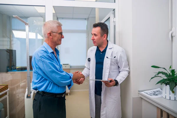 Patient und Arzt geben sich die Hand, während der ältere Patient l — Stockfoto