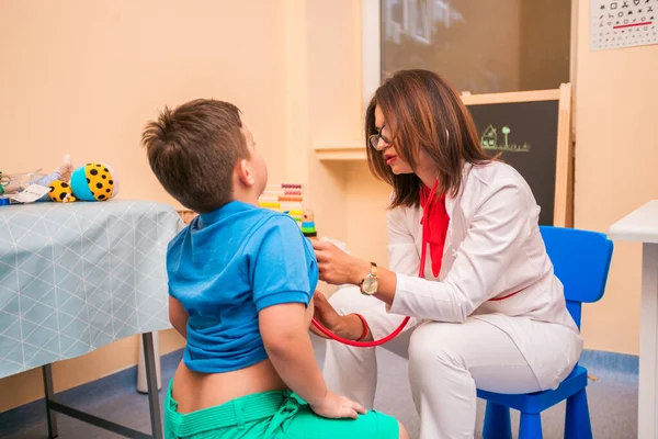 Retrato de un adorable niño visitando al doctor, luciendo valiente —  Fotos de Stock