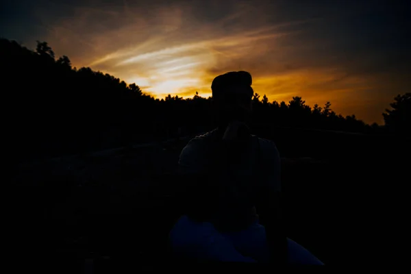 Bonito Homem Posando Belo Pôr Sol Enquanto Sentado Natureza — Fotografia de Stock