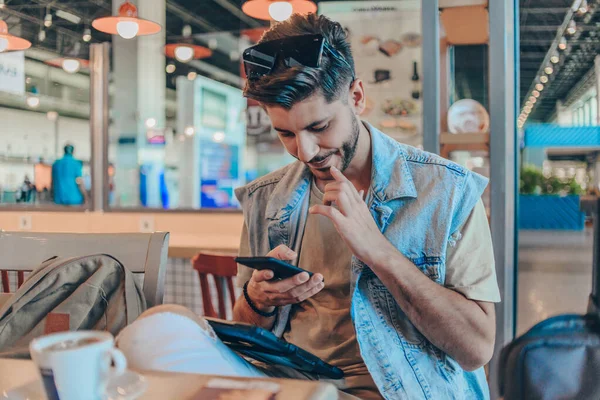 Nachdenklicher Mann Sitzt Mit Gepäck Auf Tisch Flughafen Wartebereich — Stockfoto