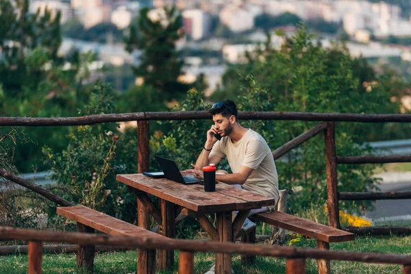Konzentrierter Mann Sitzt Tisch Mit Laptop Und Handy Auf Dem — Stockfoto