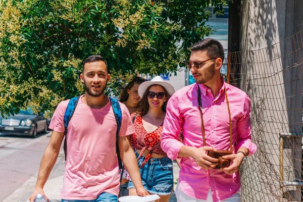 Vier Touristen (Entdecker) spazieren in einer mediterranen Stadt — Stockfoto