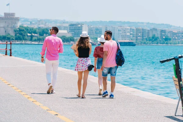 Turistas que visitam uma cidade enquanto caminham em um calçadão em um su — Fotografia de Stock