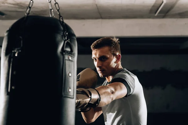 Młody Mięśniak Kickboxing Fighter Ćwiczy Kopnięcia Workiem Bokserskim — Zdjęcie stockowe