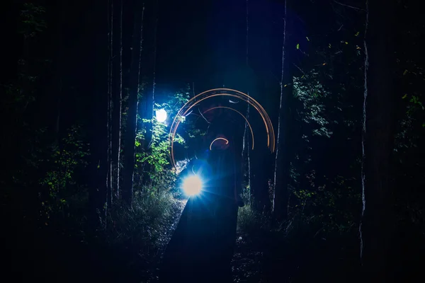 Man in tovenaarsgewaad en pet met een gloeiende staf — Stockfoto