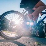 Passar manlig cyklist cykling rider sin cykel på en asfalterad väg