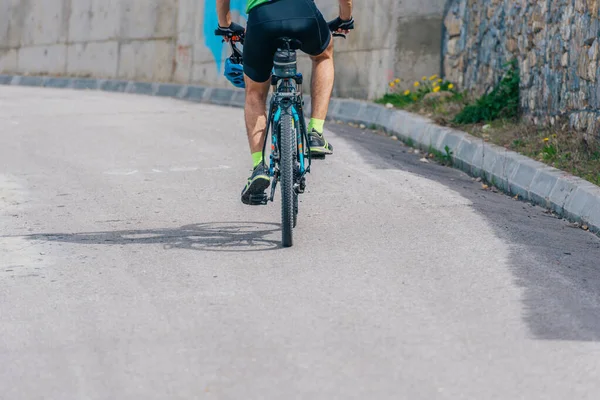 Sportovní cyklista jezdí na kole do kopce, na sobě profesionální cyklistika — Stock fotografie