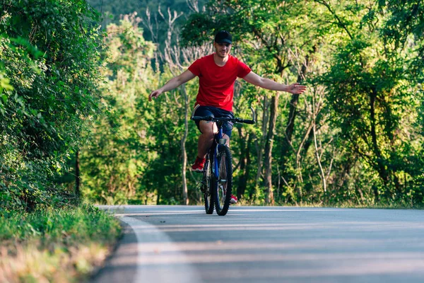 Šťastný cyklista jízda na kole přes zelené lesy. — Stock fotografie