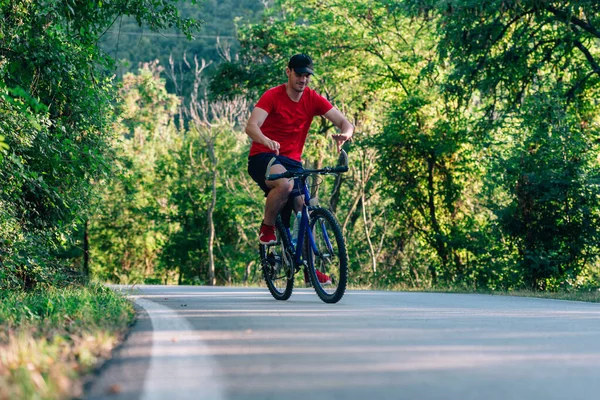 초록 숲 속을 자전거를 타고 다니는 행복 한 자전거 선수. — 스톡 사진