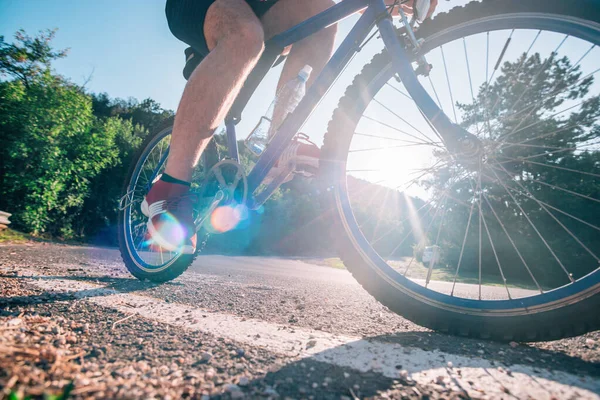 Adatto ciclista biker maschile in sella alla sua bicicletta su una strada asfaltata — Foto Stock