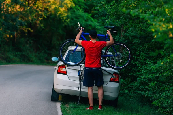 Zmęczony (wyczerpany) motocyklista umieszcza rower na samochodzie, aby się przejechać. — Zdjęcie stockowe