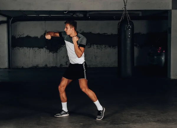 Sport concept. Sportsman muay thai boxer fighting on dark background