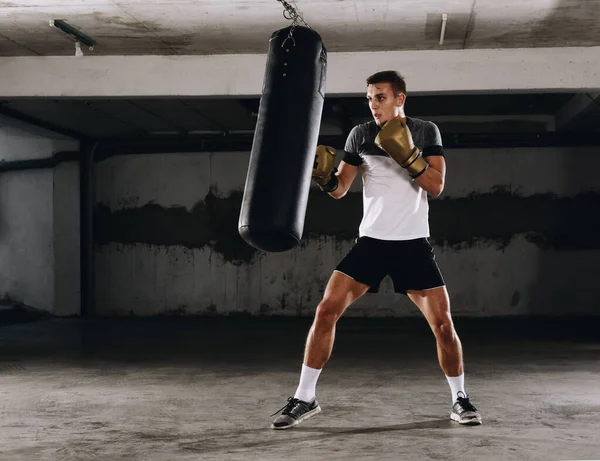 轮廓男拳击手击中了一个巨大的拳击袋在拳击工作室 男子拳击手刻苦训练 — 图库照片