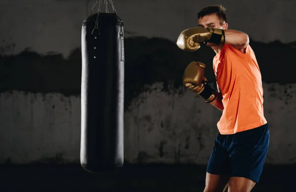年轻的拳击手在体育馆做一些拳击袋的训练 带拳击袋的高加索拳击手体操训练 健康生活方式的概念 — 图库照片
