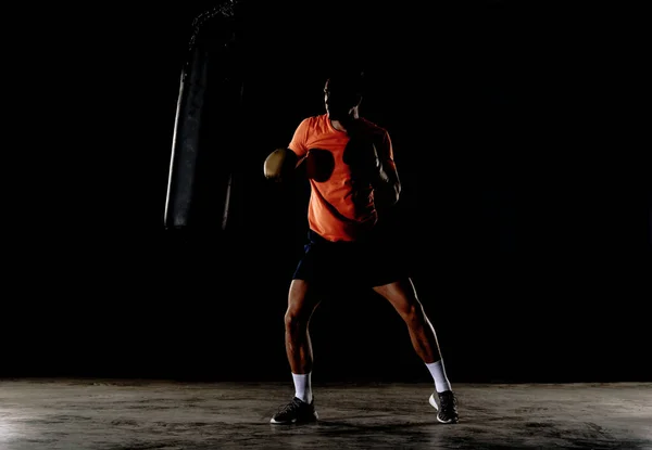 若いボクサーの男がパンチングバッグのトレーニングをしている 手袋を身に着けているパンチングバッグと白人ボクサートレーニング — ストック写真