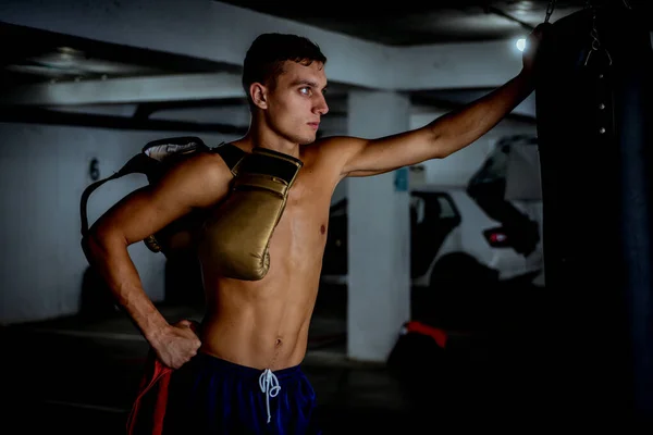 Professional young boxer after boxing training in garage