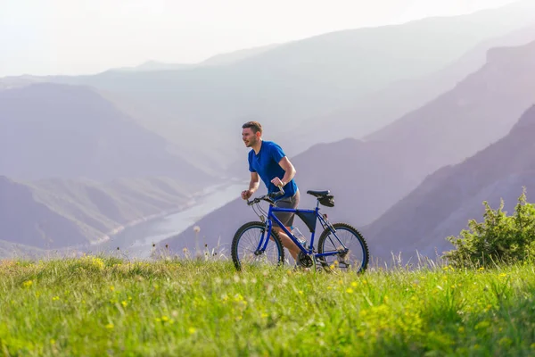 Tired fit mountain biker pushing his bike uphill at the top of t — Stock Photo, Image
