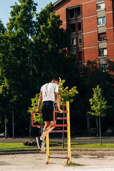 Muskulös Man gör en horisontell dra på Bar i stadsparken — Stockfoto